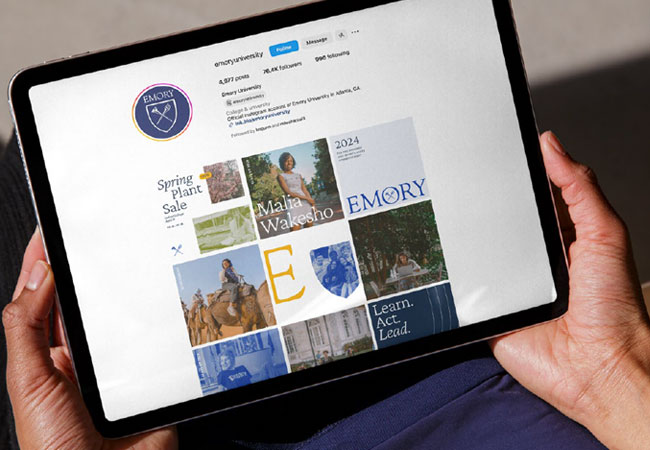 hands holding a mobile device with Emory social media displayed